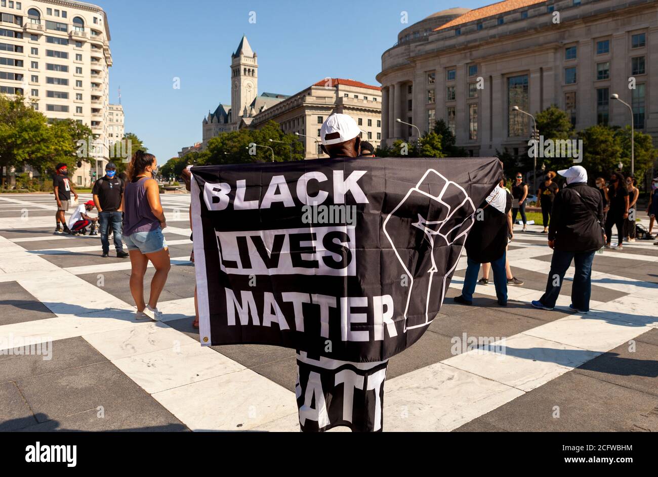 Washington, DC, USA, September 7, 2020. Pictured: A protester displays a Black Lives Matter flag during Let Freedom Sing at Freedom Plaza, with the Trump Hotel in the background. Let Freedom Ring was a community-building protest, celebration of black music, and voter registration event by the Freedom Day Foundation and Head Count. Credit: Allison C Bailey/Alamy Credit: Allison Bailey/Alamy Live News Stock Photo