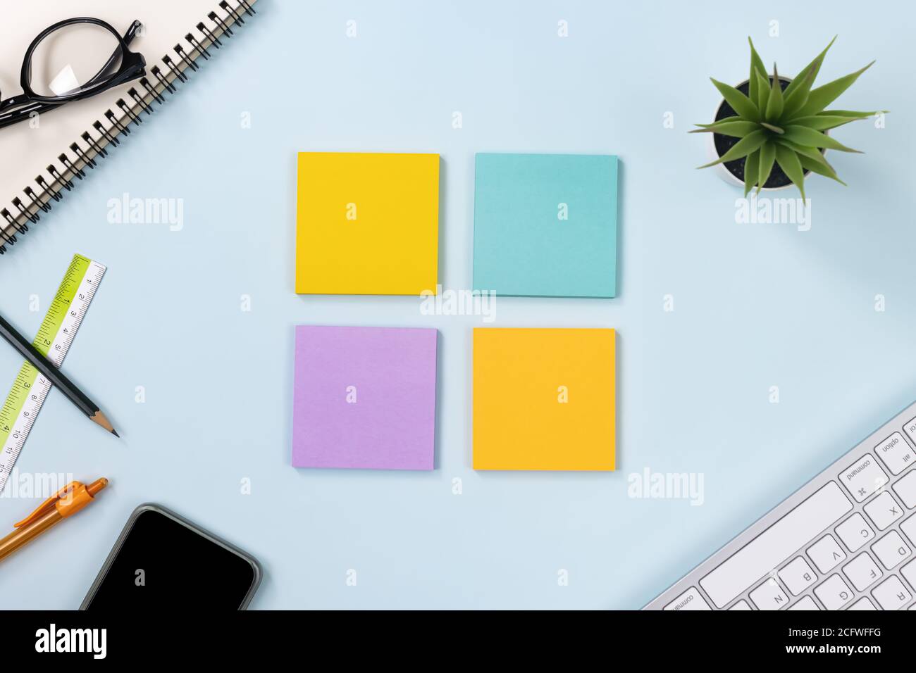 4 Sticky Note or Note Pad and Office Supplies as Keyboard,Pen,Pencil,Office Plants,Spiral Notebook,Glasses,Ruler,Mobile Phone on Modern Clean Creative Stock Photo