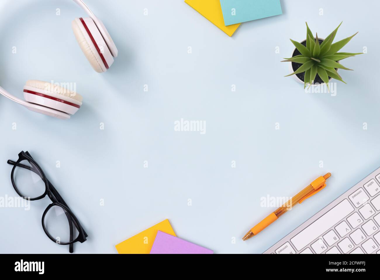 Modern Clean Creative Office Desk or Table on Top View or Flat Lay and Stationery as Keyboard,Headphone,Pen,Sticky Note,Office Plants,Glasses Stock Photo