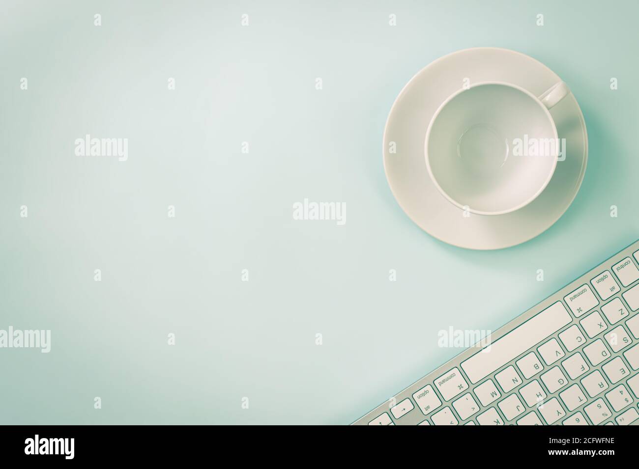 Coffee Cup and Computer Keyboard on Modern Clean Creative Office Desk or Office Table on Top View or Flat Lay. Blue Workspace Minimalist Background Stock Photo