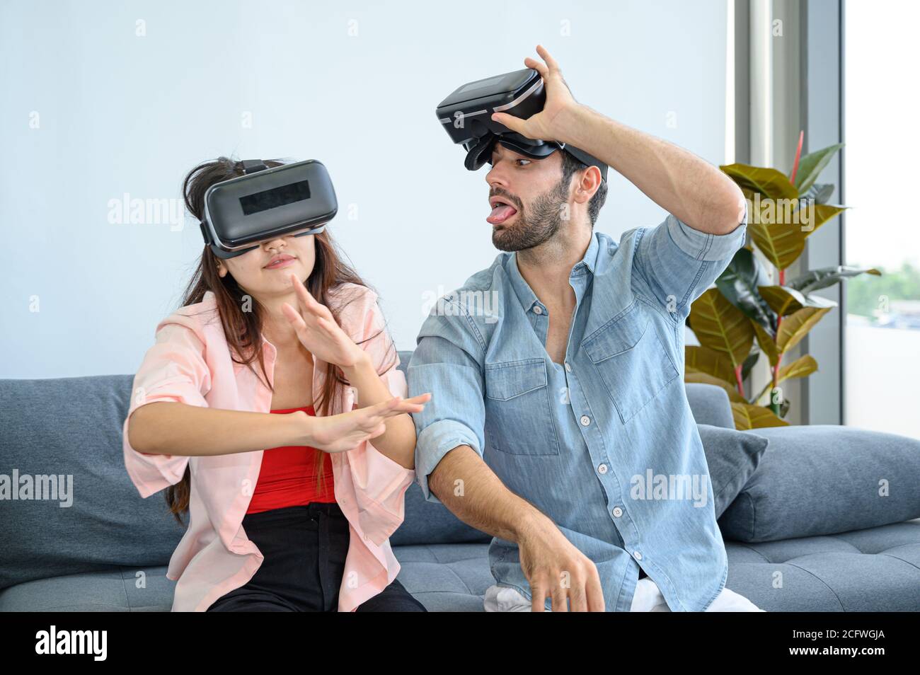 Couple lovers enjoy  playing VR game together at home. Family relationship concept. Stock Photo