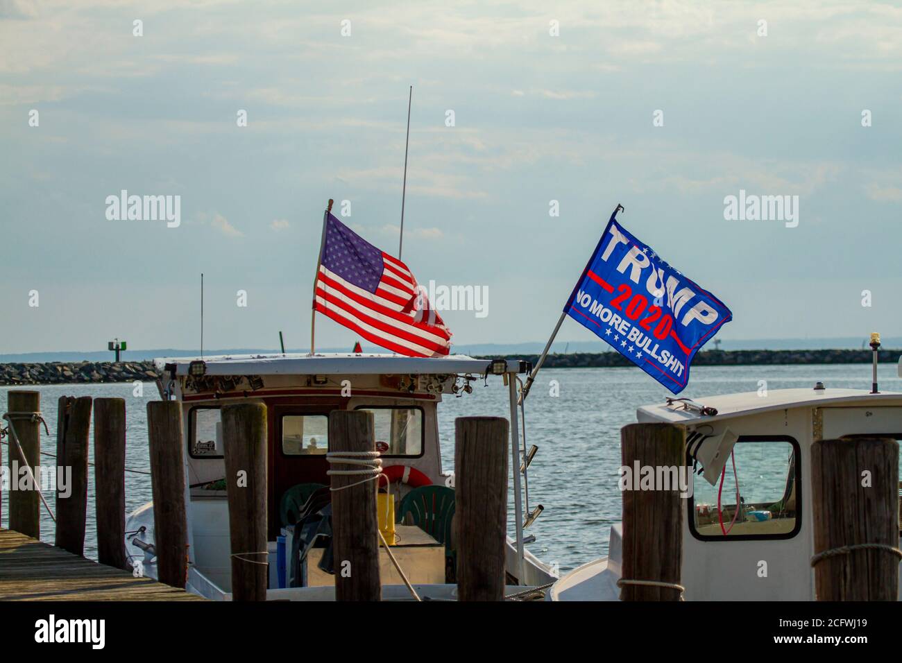 Rock hall, MD ,USA 08/18/2020: Trump 2020 flag waving on a flag post at the back of a boat. The flag has a slogan saying 'No More Bullshit'.  An Ameri Stock Photo