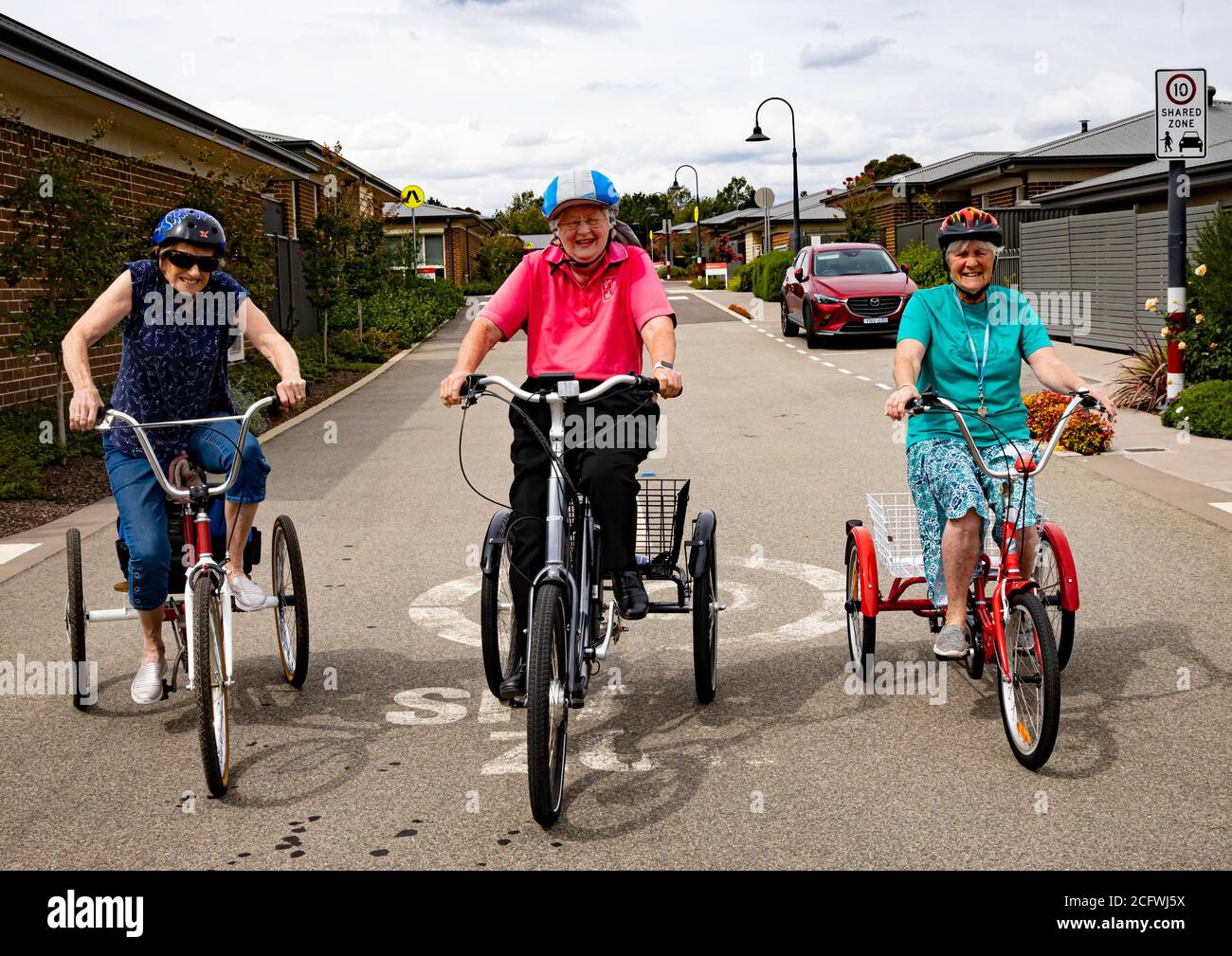 Three women exercise on tricycles at Isabella Gardens Retirement Village in Canberra during Covid-19 lockdown in Australia Stock Photo
