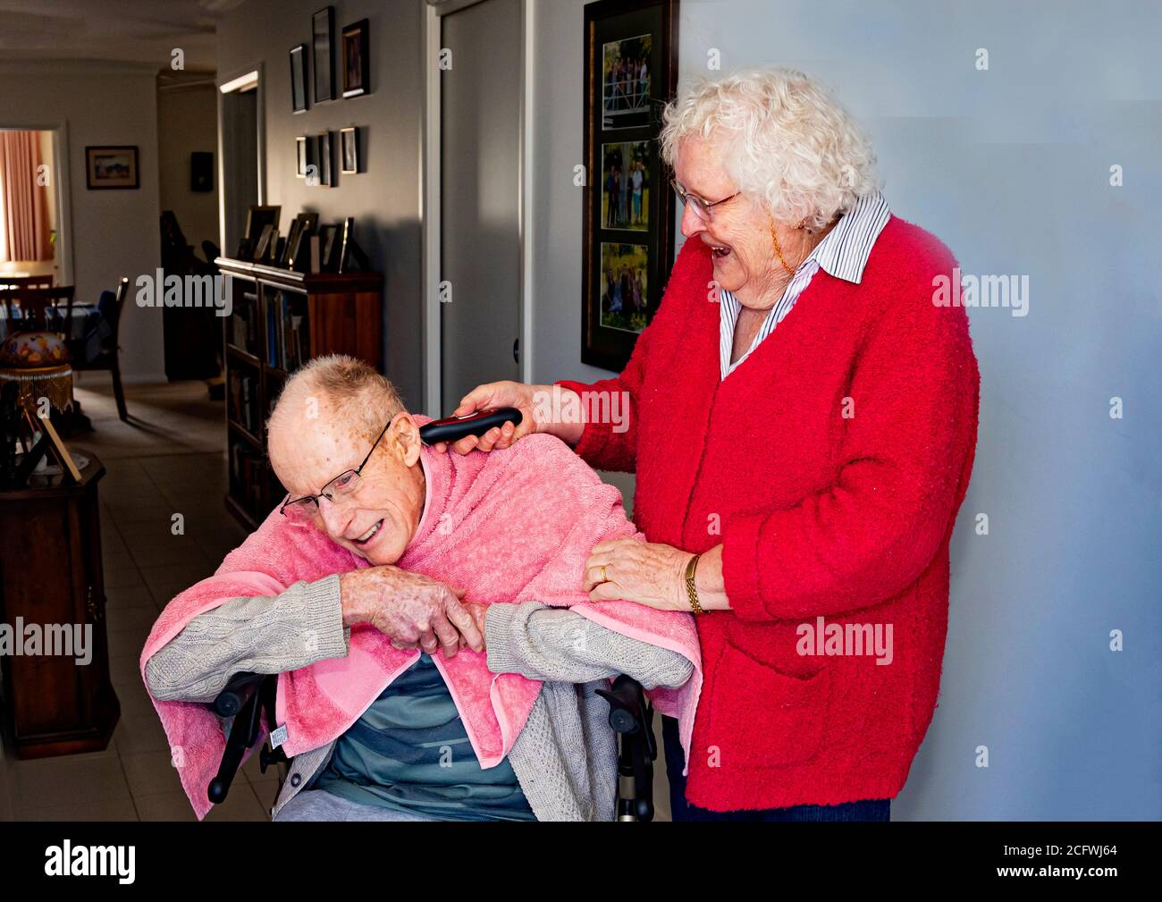 Wife gives hair cut to Australian pensioner husband living at retirement village in Canberra who can't get to barbershop during Covid 19 lockdown Stock Photo