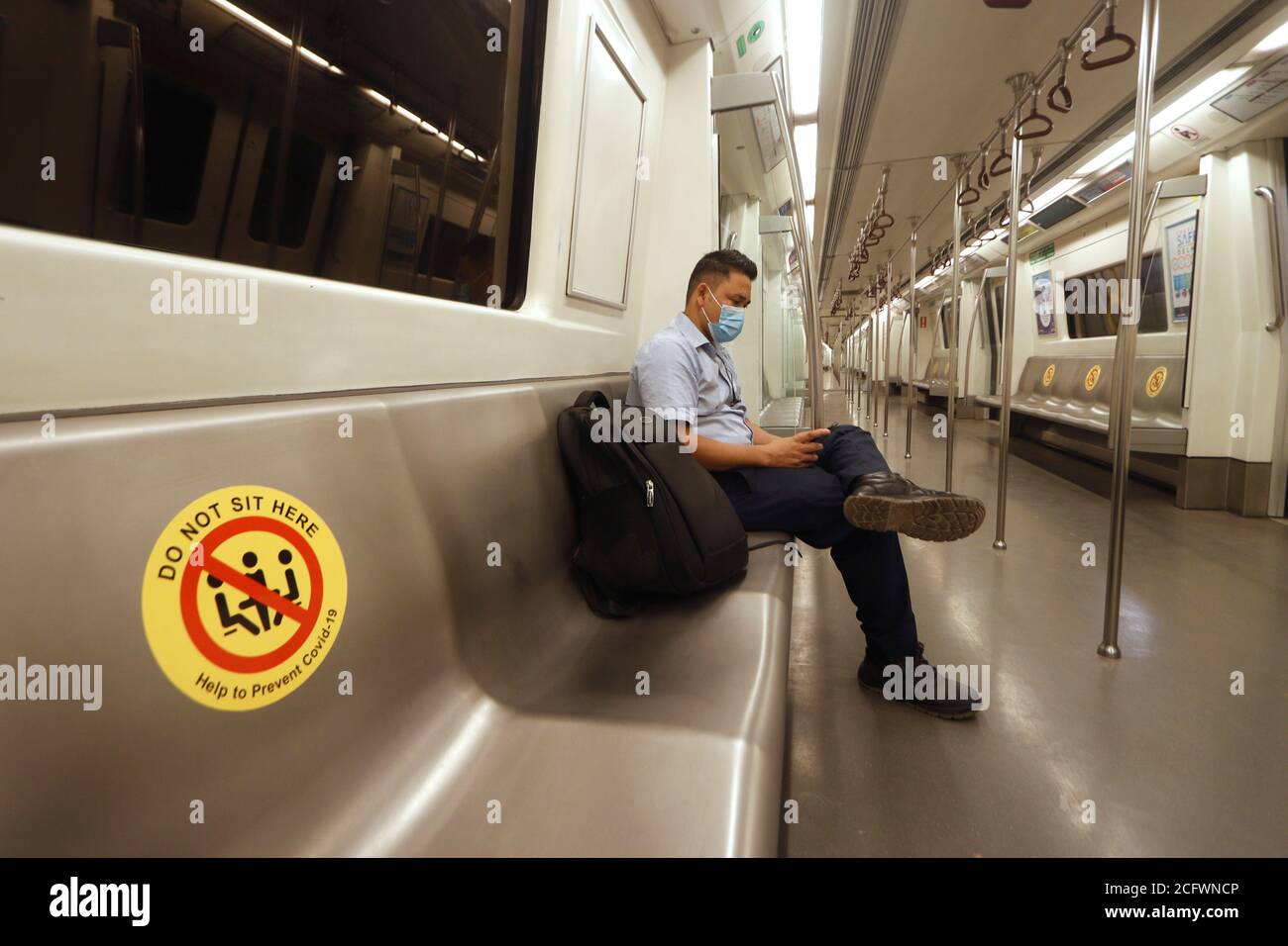 New Delhi, India. 07th Sep, 2020. A man wears a facemask and observes social distance while traveling on Delhi Metro on its first day of reopening after 5 months of lockdown due to Covid-19.On the first day, the yellow line between HUDA City Centre and Samaypur Badli, will run from 7 to 11 am, and 4 to 8 pm in the 2nd phase. The metro will resume full services from September 12. Credit: SOPA Images Limited/Alamy Live News Stock Photo