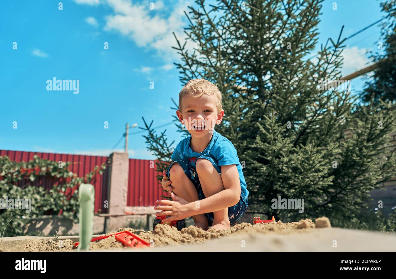 Cute baby boy playing with sand in a sandbox Stock Photo - Alamy