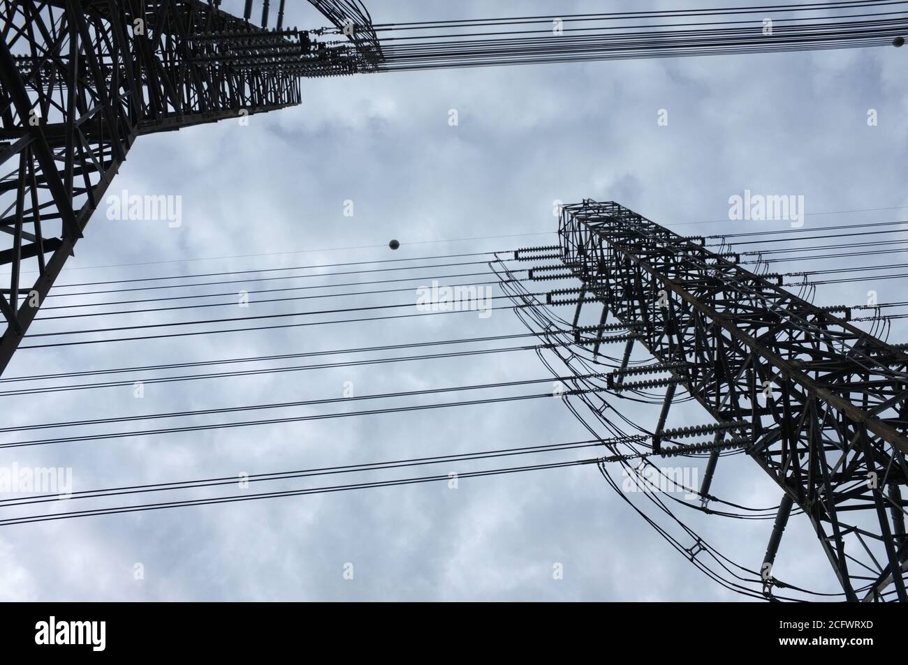 Close up view , high voltage power lines station. High voltage electric transmission pylon silhouetted tower. Stock Photo