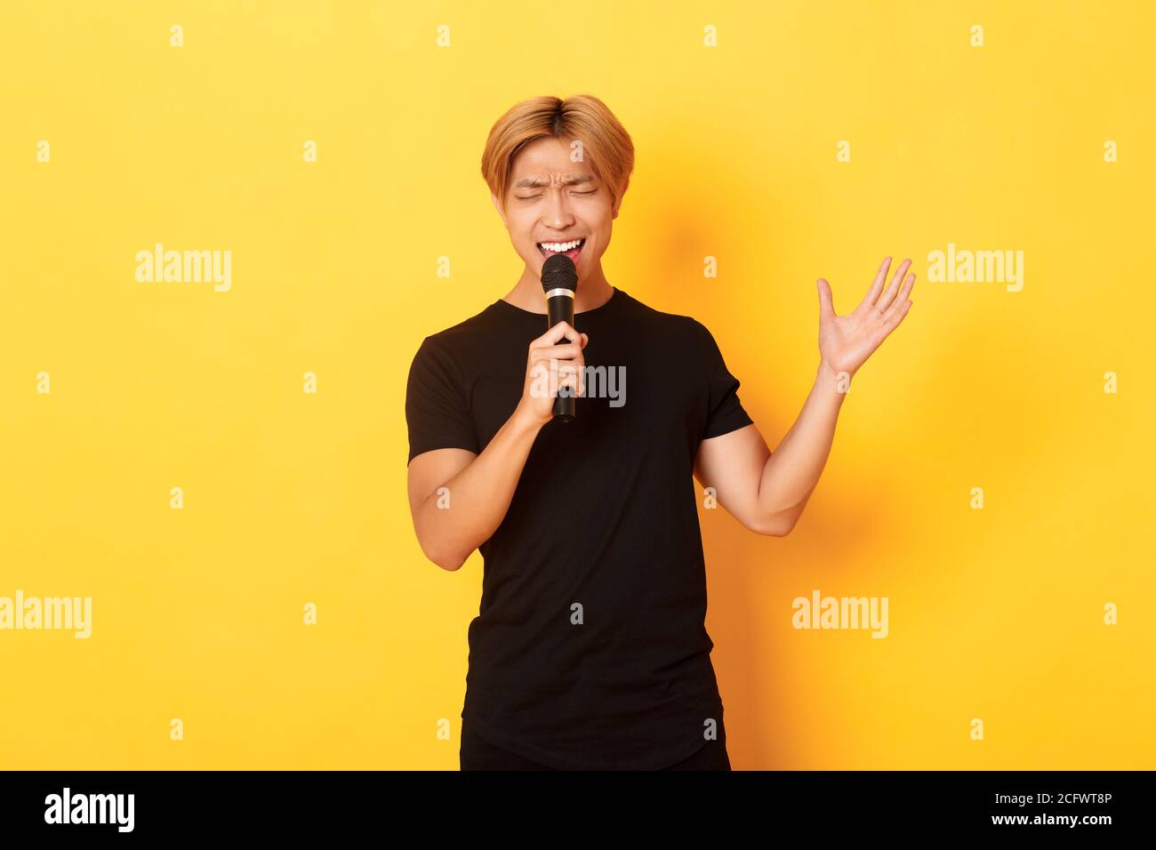 Handsome asian male singer, korean guy singing song at karaoke in