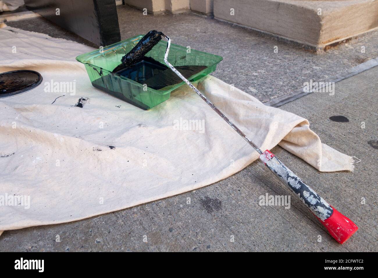 Small roller with black paint on throw trap and Paint Roller tray Stock