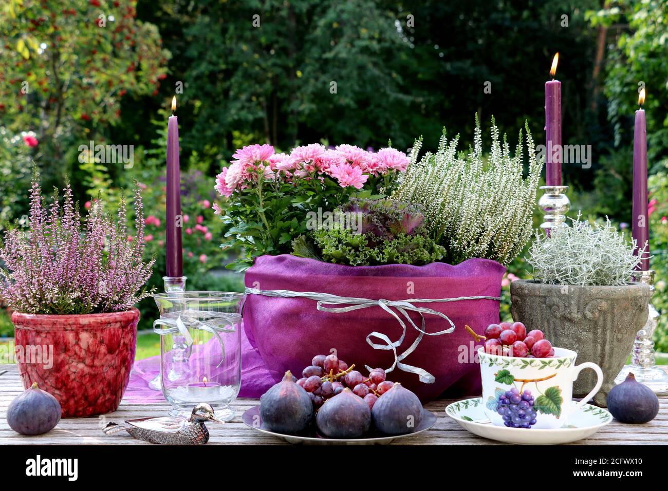 autumn table decoration with figs, grapes, flowers and candles Stock Photo