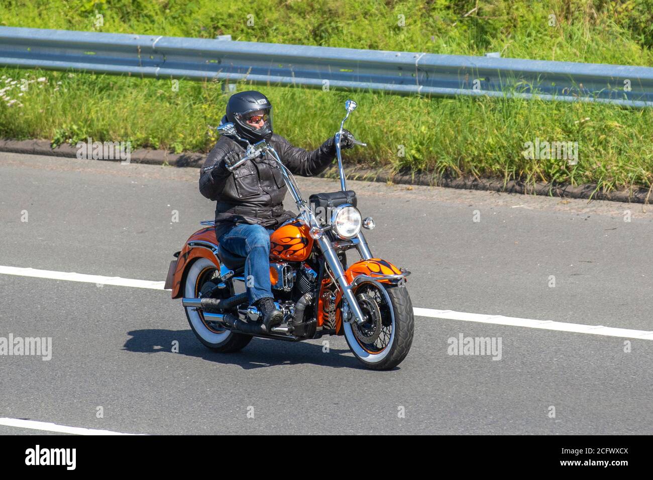 Orange high handlebars harley motorcycle Motorbike rider; two wheeled  transport, motorcycles, vehicle, roads, motorbikes, bike riders motoring in  Chorley, UK Stock Photo - Alamy