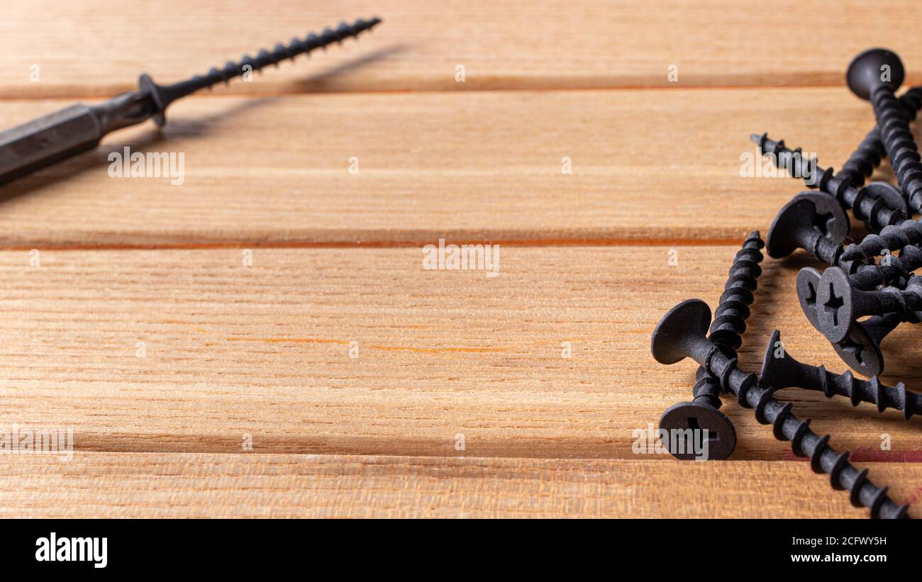 A screwdriver and self-cutters on a brown wooden background. Building tools to repair the house. Stock Photo