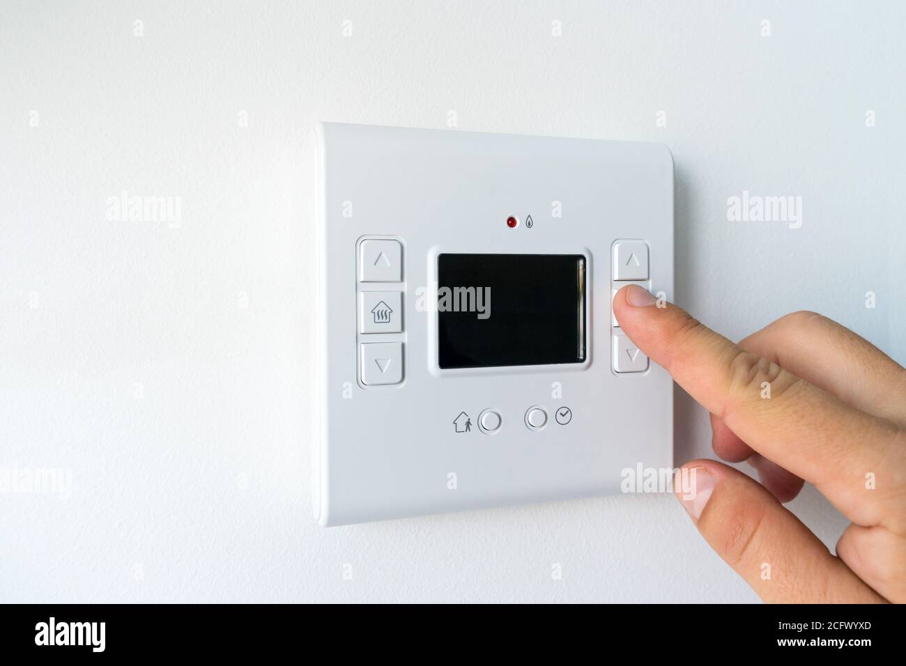 Man hand setting the room temperature on a modern programmable