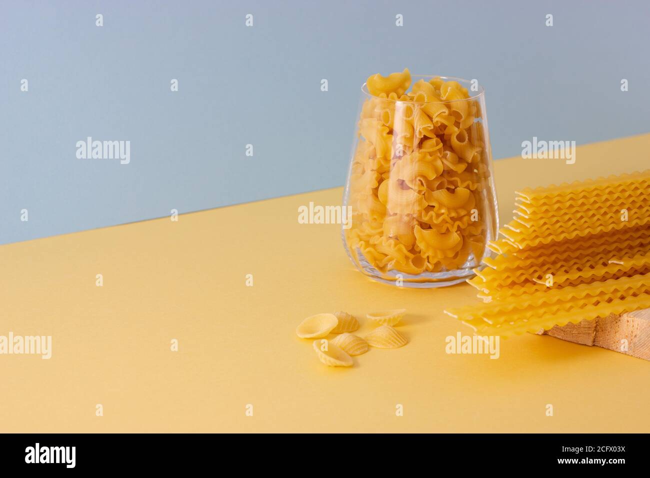 Different types of uncooked pasta, color background with copy space ...