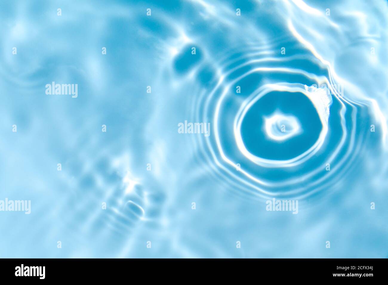 Blurred transparent blue colored clear calm water surface texture with ...