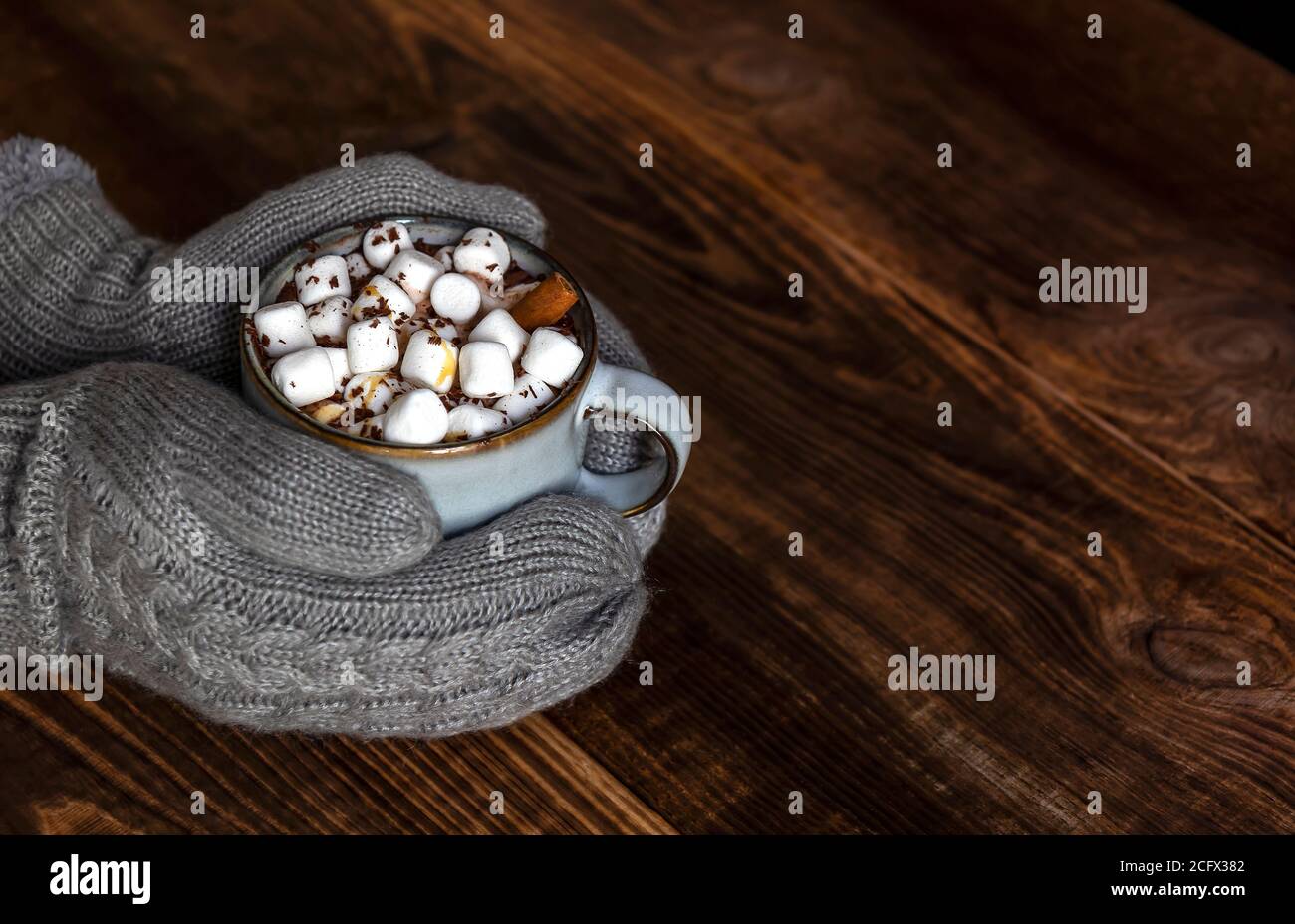 https://c8.alamy.com/comp/2CFX382/hands-in-mittens-hold-cup-of-hot-cocoa-or-chocolate-with-marshmallow-2CFX382.jpg