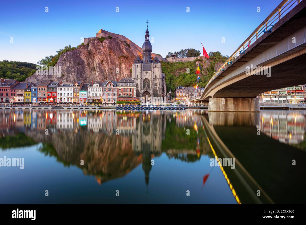 Dinant, Belgium. Cityscape image of beautiful historical city of Dinant with the reflection of the city in the Meuse River at summer sunset. Stock Photo