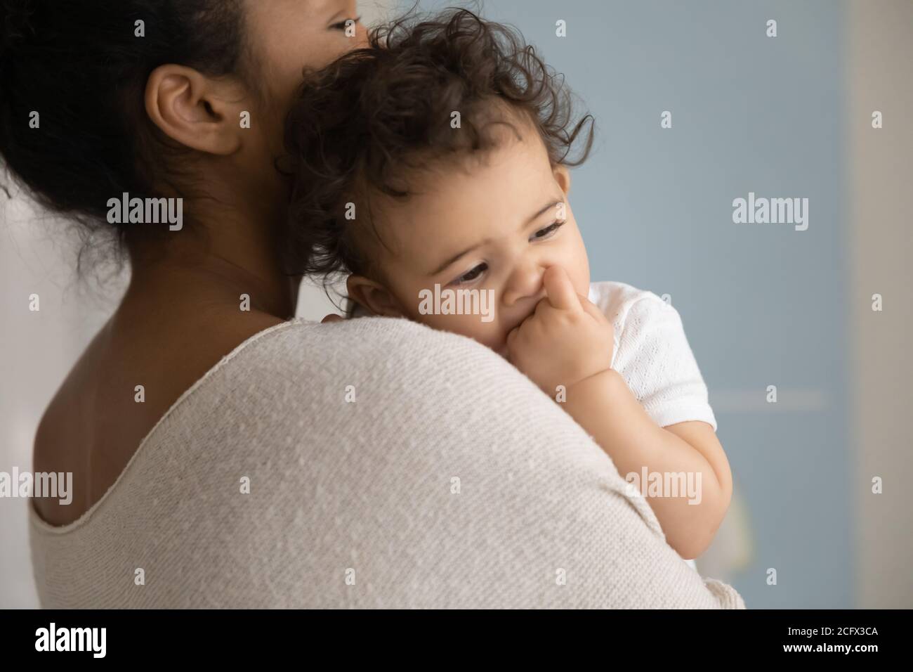 Affectionate caring young mixed race mommy holding sleeping kid. Stock Photo