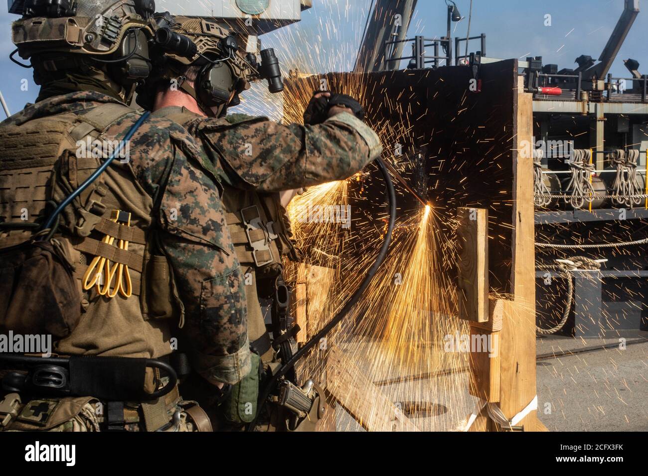 SOUTH CHINA SEA (Sep. 5, 2020) Force Reconnaissance Marines with Command Element, 31st Marine Expeditionary Unit (MEU), cut through metal during a simulated Visit, Board, Search and Seizure (VBSS) mission drills aboard dock landing ship USS Germantown (LSD 42). VBSS is a part of Maritime Interception Operations that aim to delay, disrupt, or destroy enemy forces or supplies in the maritime domain. Germantown, part of the America Amphibious Readiness Group (ARG), 31st MEU team, is operating in the U.S. 7th Fleet area of operations to enhance interoperability with allies and partners and serve a Stock Photo