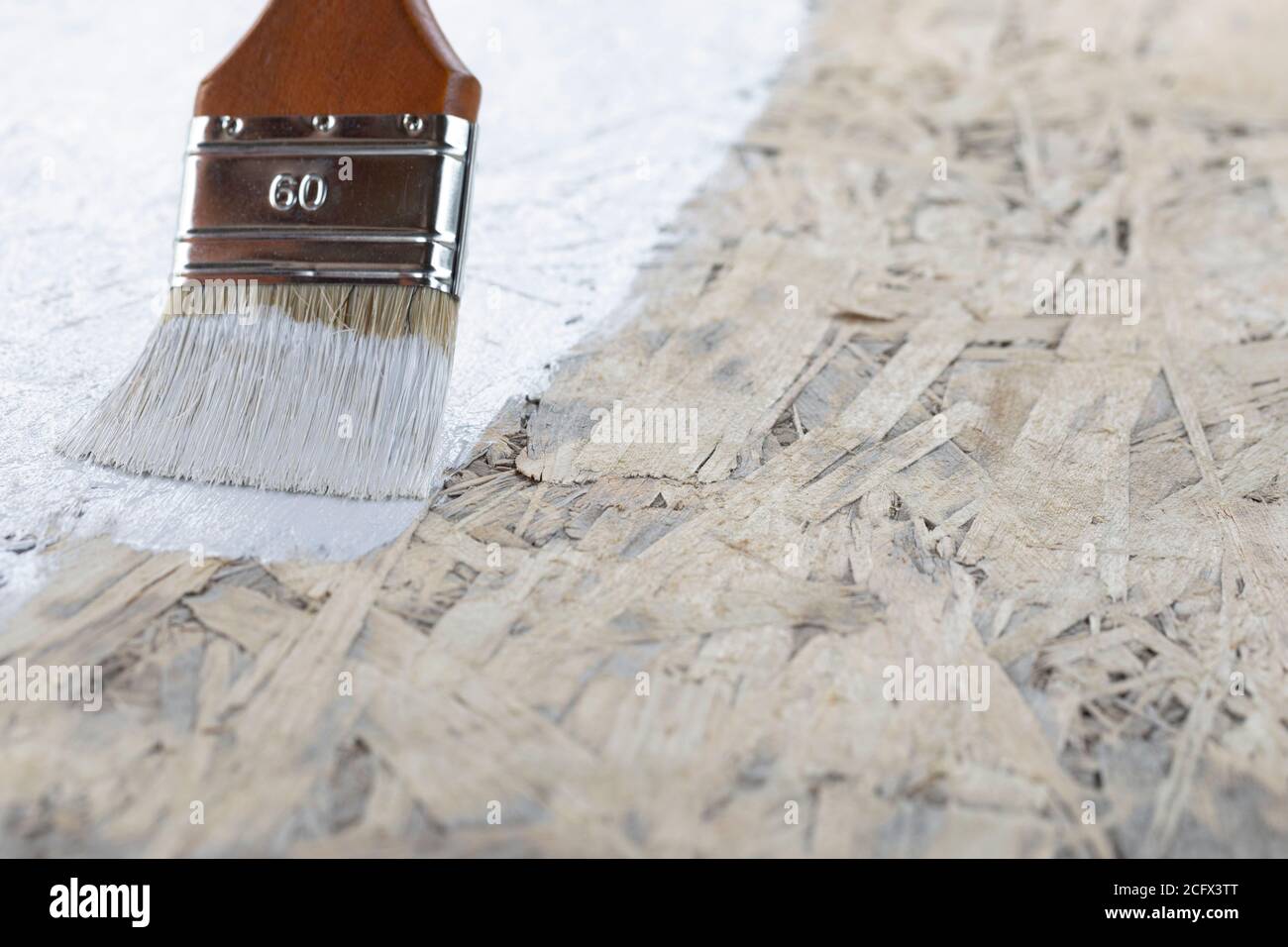 Brush painting wall with white paint. Close up Stock Photo