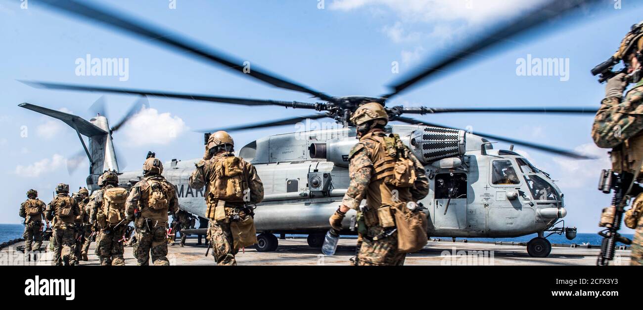 SOUTH CHINA SEA (Sept. 6, 2020) Force Reconnaissance Marines with Command Element, 31st Marine Expeditionary Unit (MEU) board a CH-53 E Super Stallion helicopter with Marine Medium Tiltrotor Squadron (VMM) 262, for extraction during a visit, board, search and seizure exercise aboard the amphibious dock landing ship USS Germantown (LSD 42). Germantown, part of the America Amphibious Ready Group assigned to Amphibious Squadron 11, along with the 31st Marine Expeditionary Unit, is operating in the U.S. 7th Fleet area of responsibility to enhance interoperability with allies and partners, and serv Stock Photo