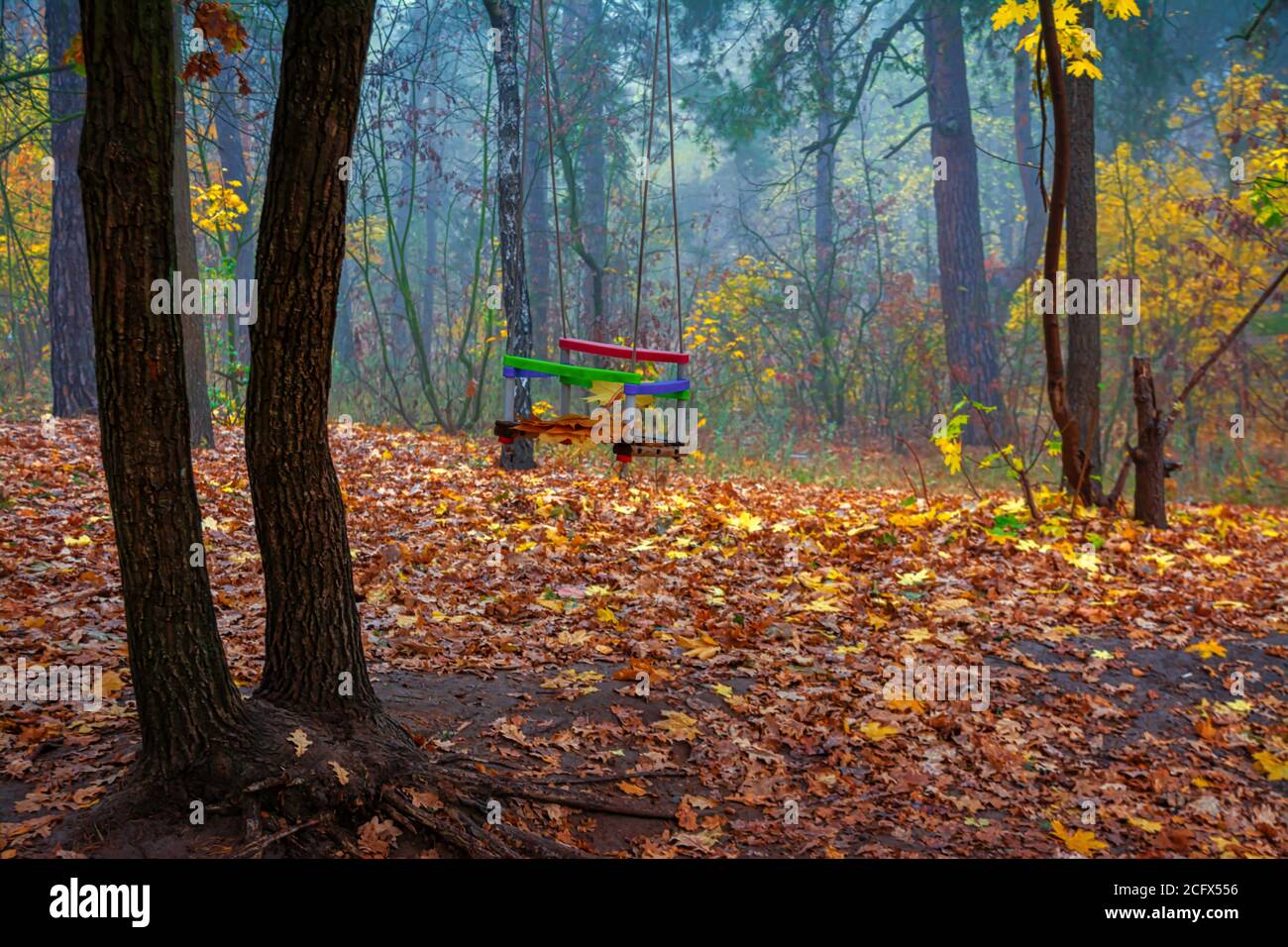 Forgotten children's swing on the background of an autumn park Stock Photo