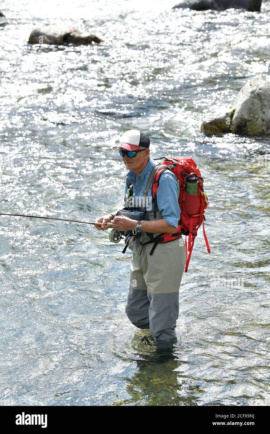 https://c8.alamy.com/comp/2CFX9NJ/fly-fisherman-trout-fishing-with-a-hiking-backpack-and-a-blue-shirt-in-the-high-mountains-in-summer-2CFX9NJ.jpg