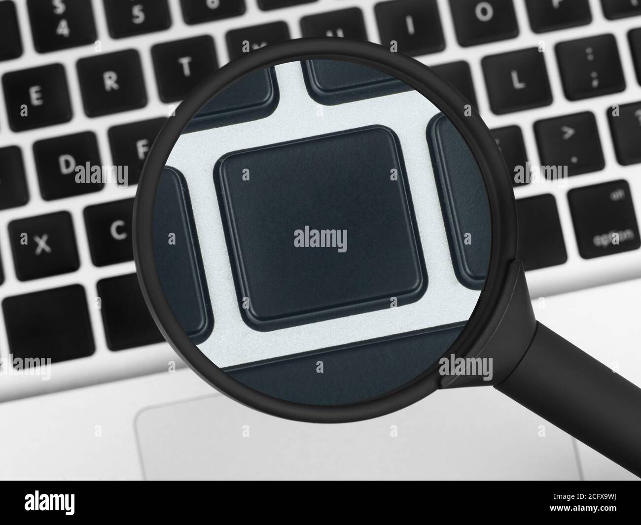 Magnifying glass over a laptop keyboard Stock Photo - Alamy