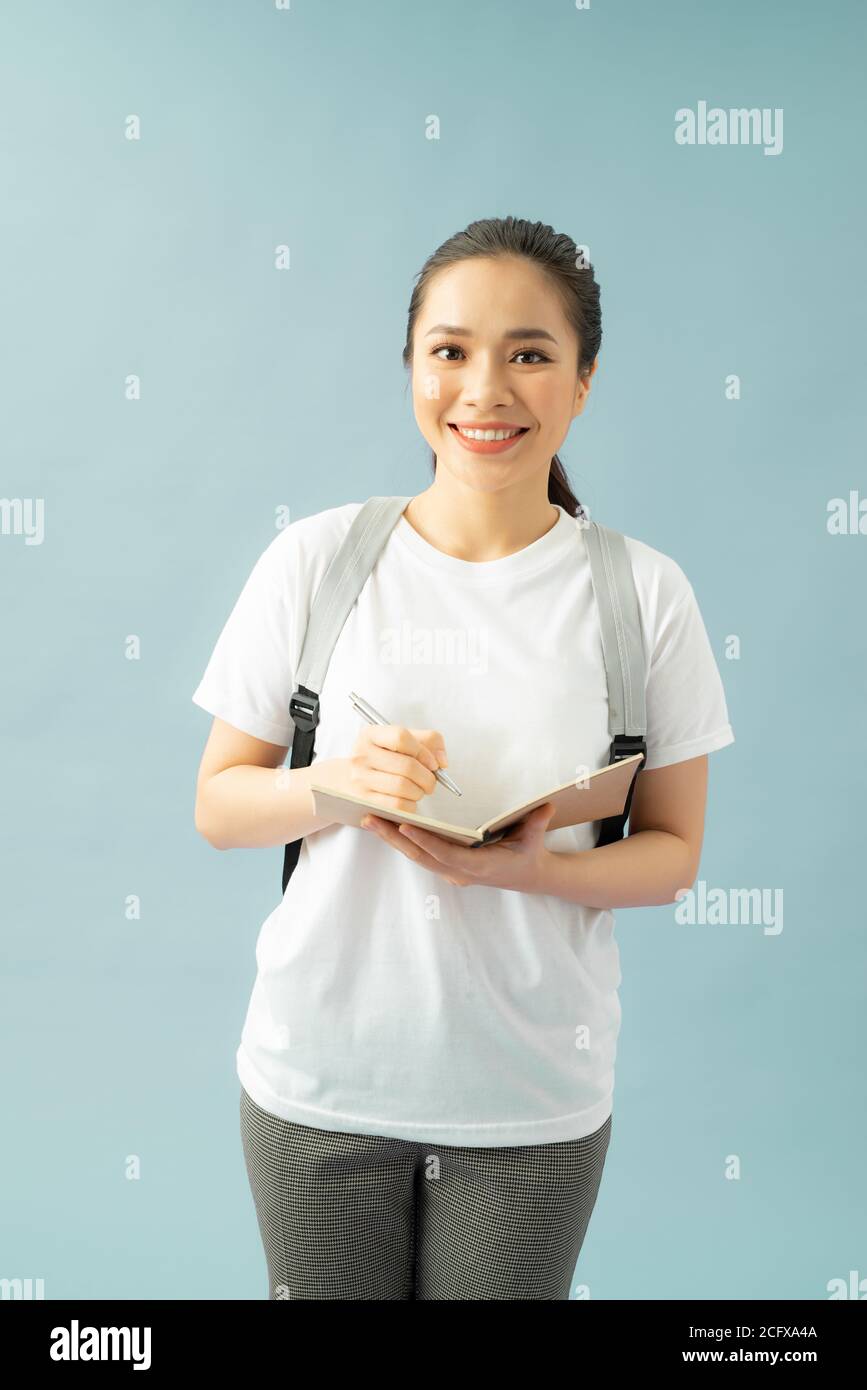 Portrait of a happy friendly girl student with backpack holding books ...