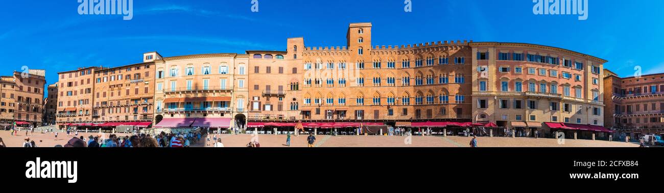 Picturesque panorama of various palazzi signorili surrounding the shell-shaped Piazza del Campo on a sunny day with a blue sky. The main square of... Stock Photo