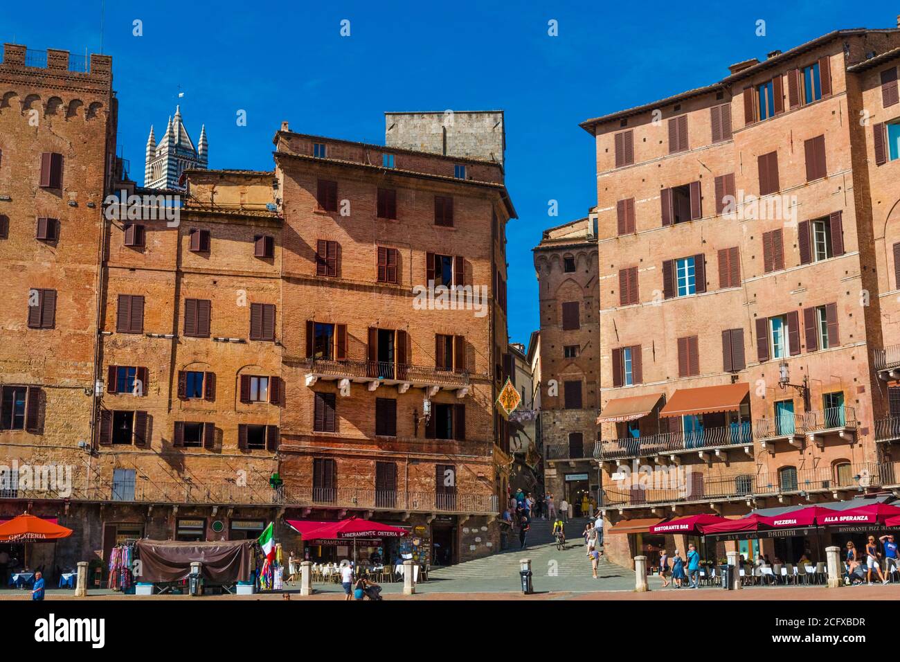 Nice view of various palazzi signorili with a gap caused by the popular Costa Barbieri street; surrounding the historic Piazza del Campo on a sunny... Stock Photo