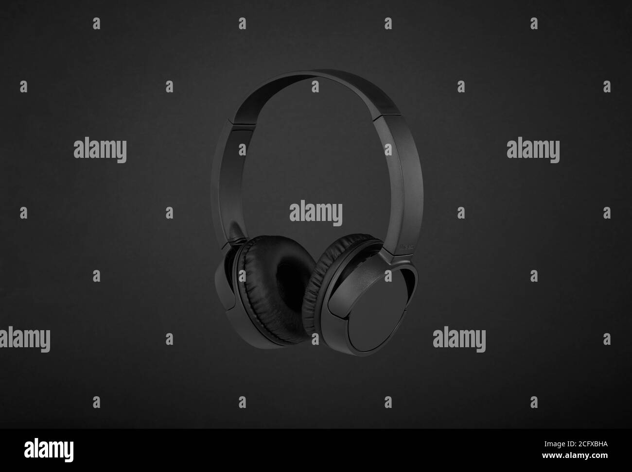 Black wireless headphones on black background Stock Photo Alamy