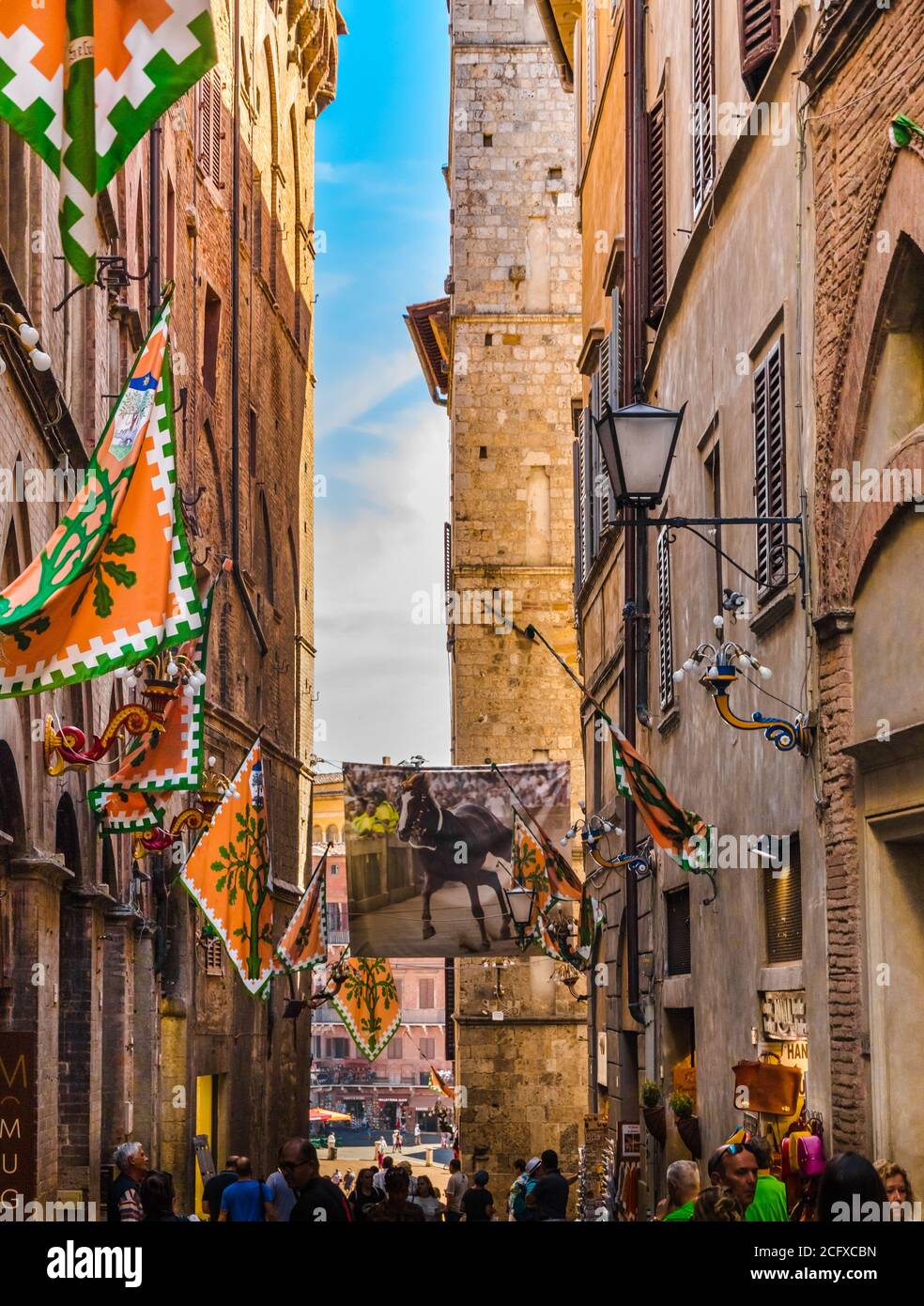 Great view of the popular Via dei Pellegrini towards the square Piazza del Campo in Siena. The street is decorated with flags from Selva, the Forest... Stock Photo