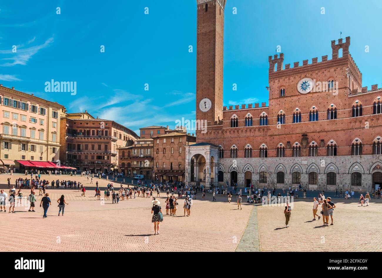Great panoramic view of the famous town hall Palazzo Pubblico with the Cappella di Piazza in the historic main square Piazza del Campo on a sunny day... Stock Photo