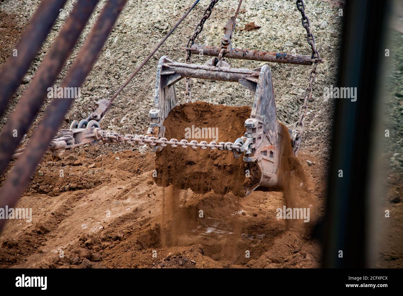 Aluminium ore quarry. Bauxite clay open-cut mining. Walking dragline excavator. bucket with empty ground (empty rocks). Stock Photo
