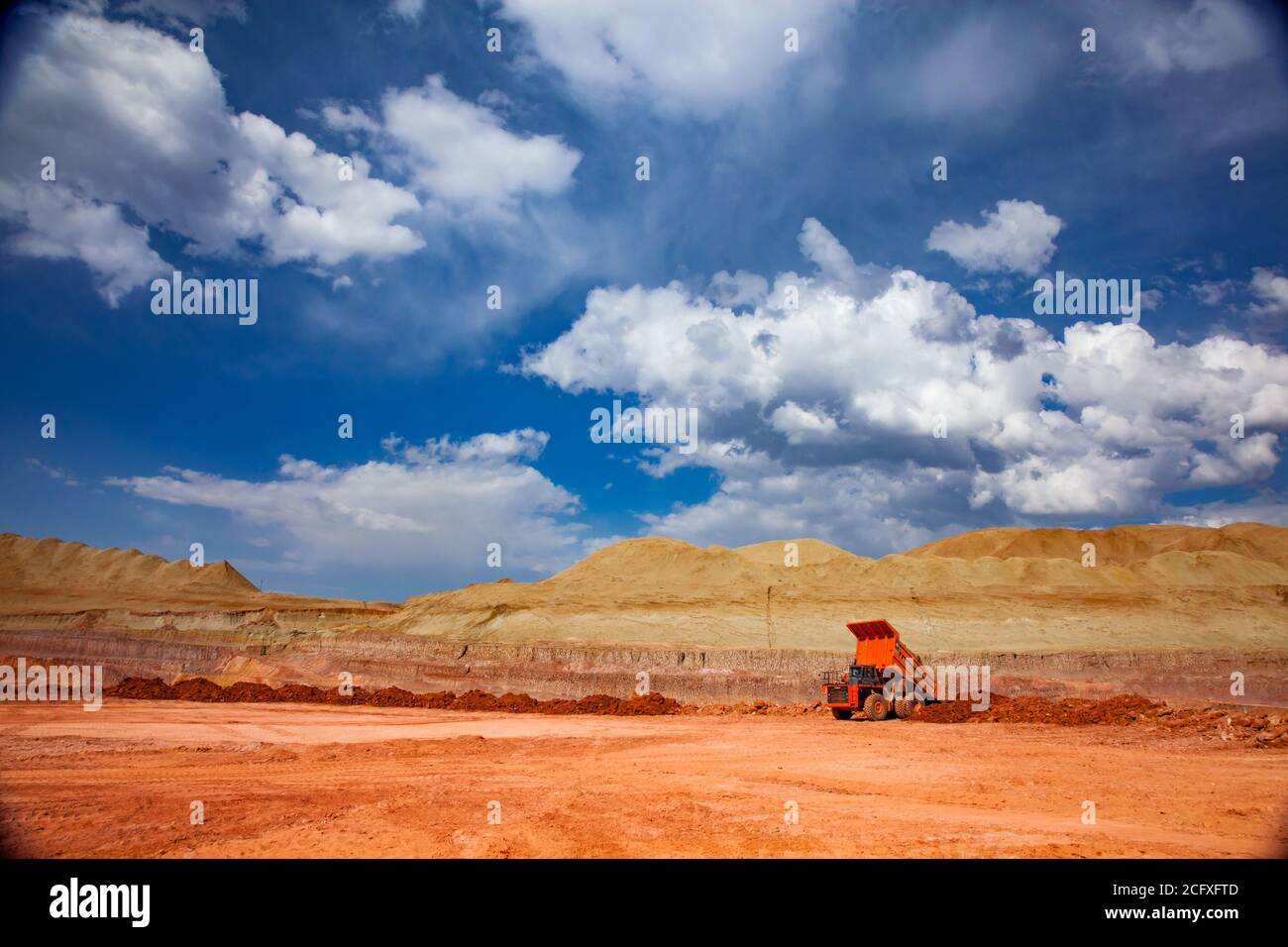 Orange quarry truck in the bauxite mine. Opencut mining of aluminium