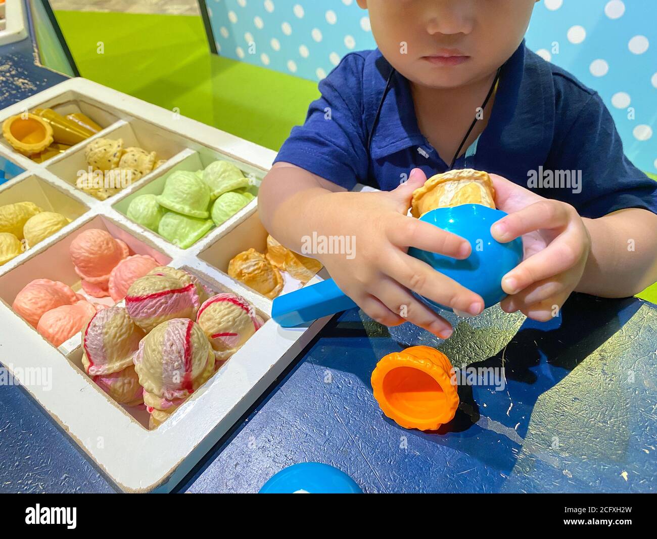 Asian happy child toddler boy playing with toy ice cream. Stock Photo