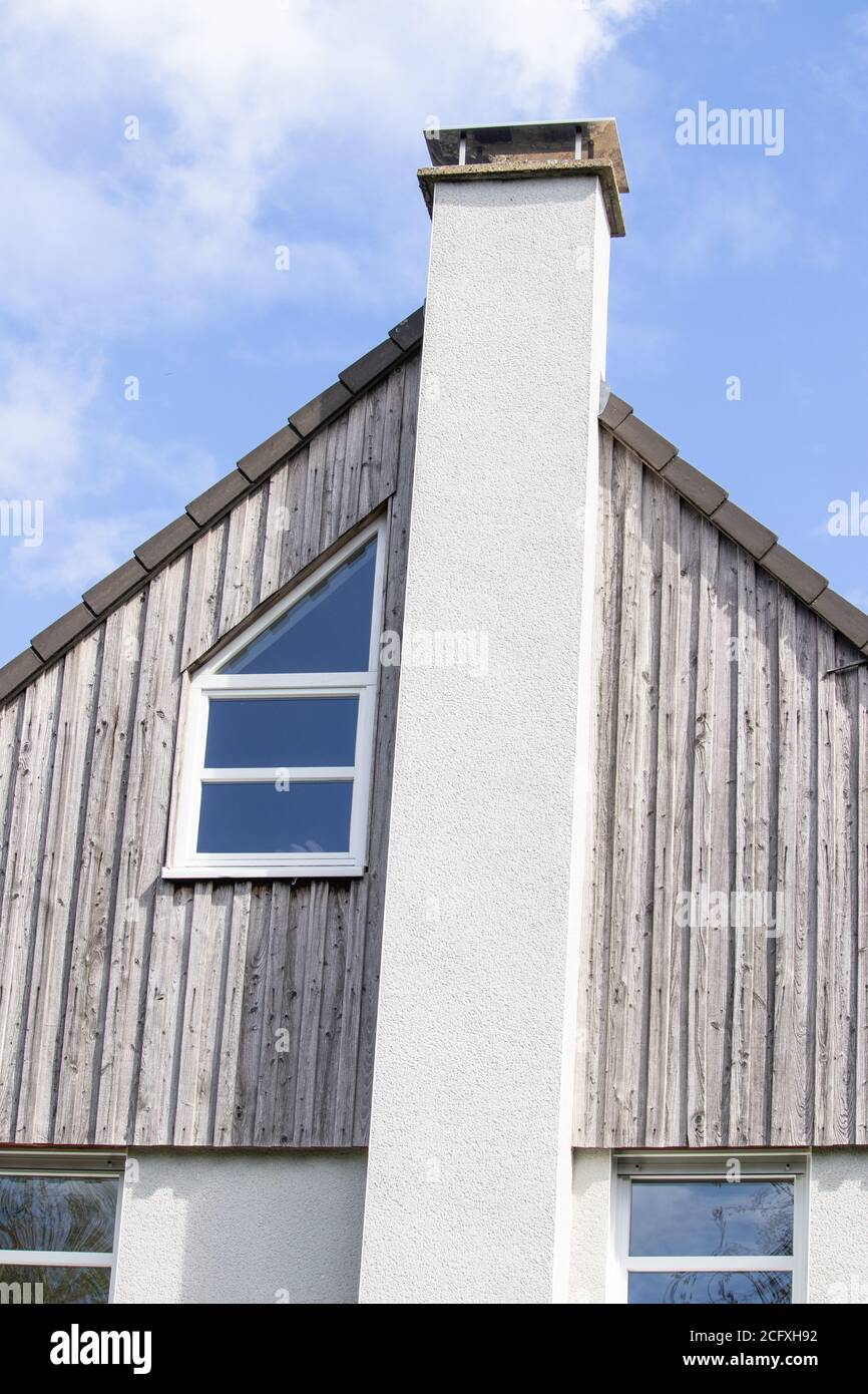 Vertical closeup shot of a wooden roof with a long white chimney Stock Photo