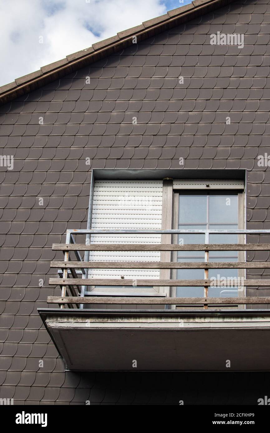Vertical closeup shot of a dark brown house top with a balcony Stock Photo