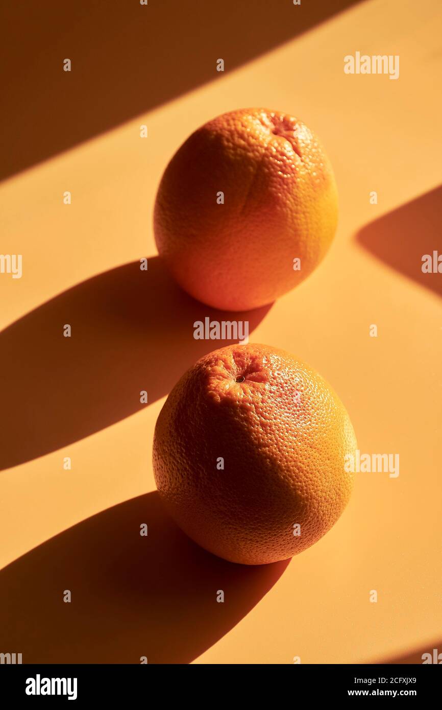 Still life of fruits on an orange background, with shadows and bright