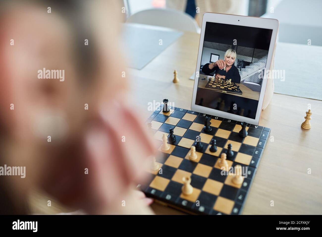 Premium Photo  Woman playing chess online on tablet computer