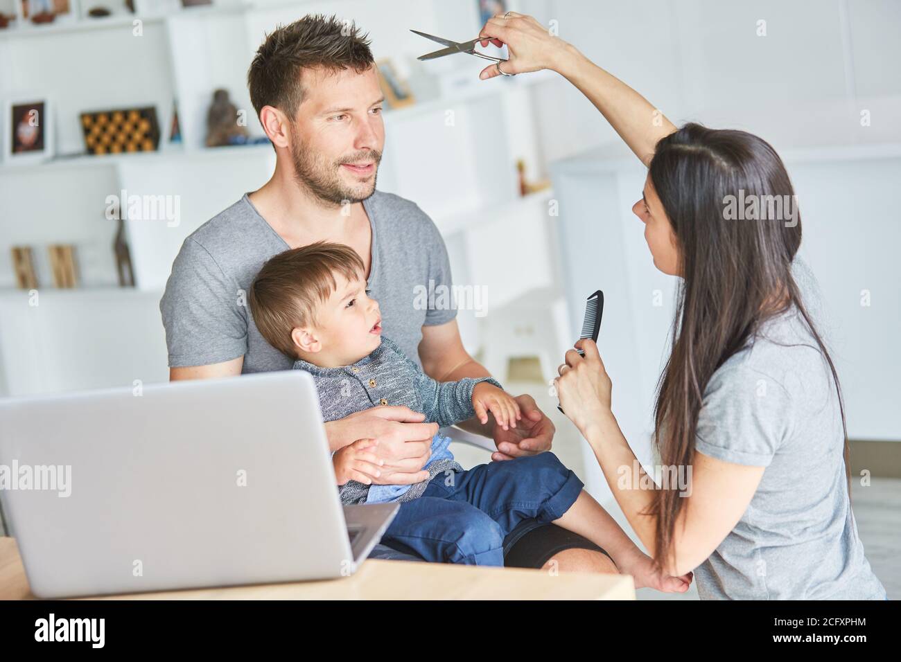 Mother with comb and scissors while cutting child's hair in the online