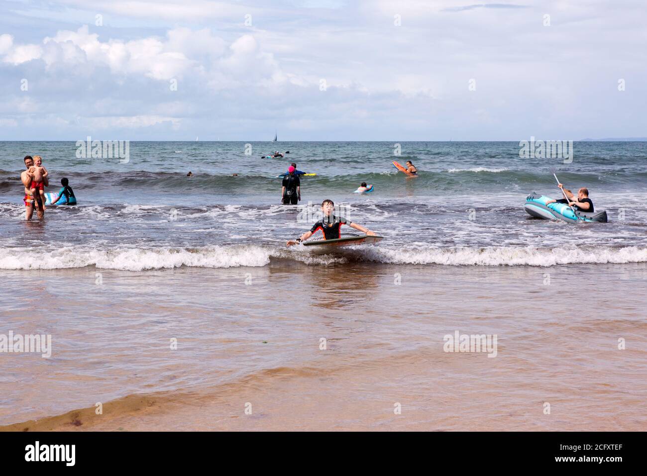 Eleven year old boy surfing at Hope Cove beach, Kingsbridge, Devon, England, United Kingdom. Stock Photo