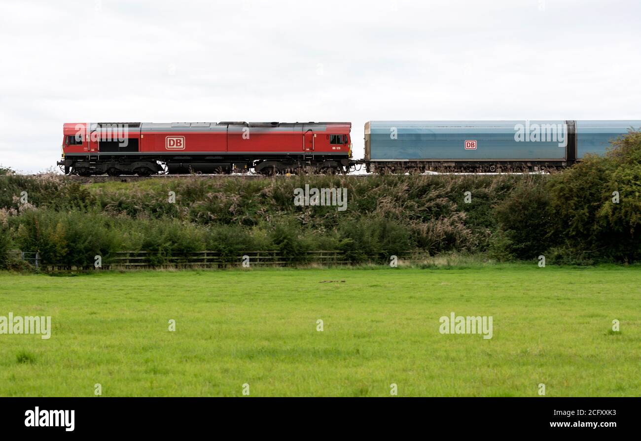 DB class 66 diesel locomotive No. 66128 pulling a car train, Warwickshire, England, UK Stock Photo