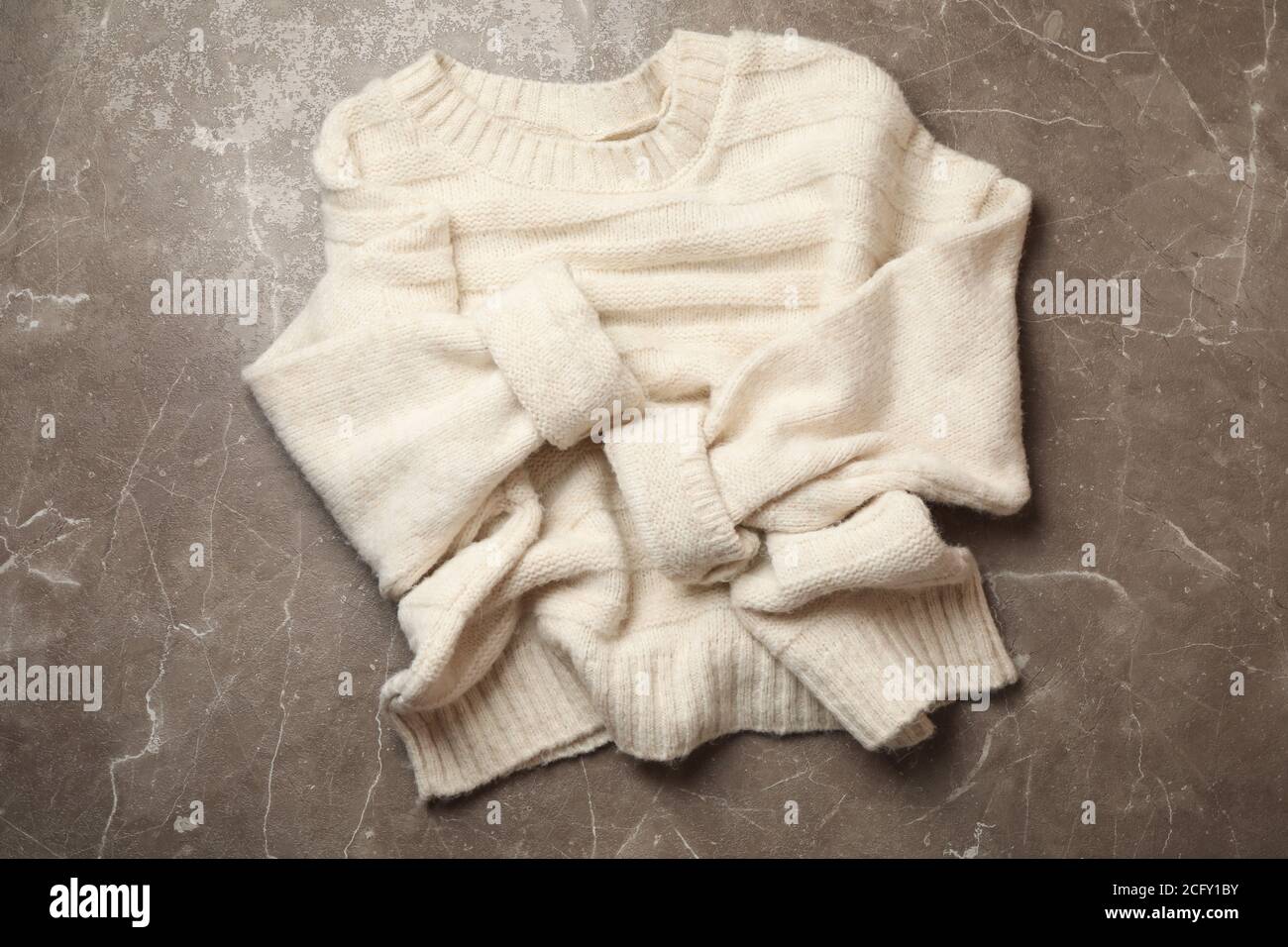 Knitted sweater on gray background, top view Stock Photo