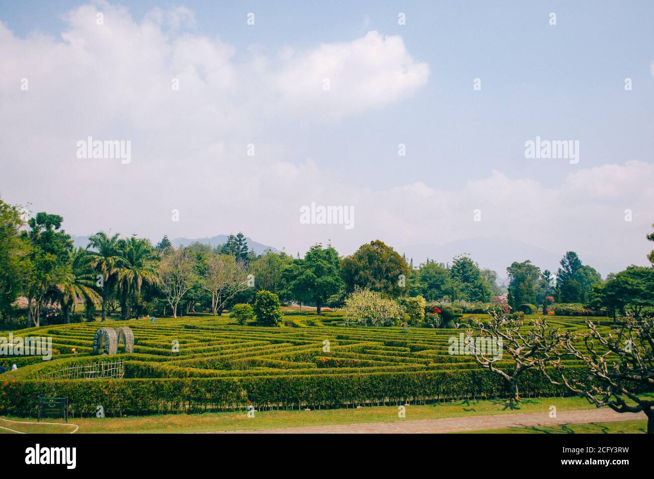 Bogor, Indonesia - A view of the flower themed park Taman Bunga Nusantara in a cloudy afternoon with a view to a labyrinth field with people walking a Stock Photo