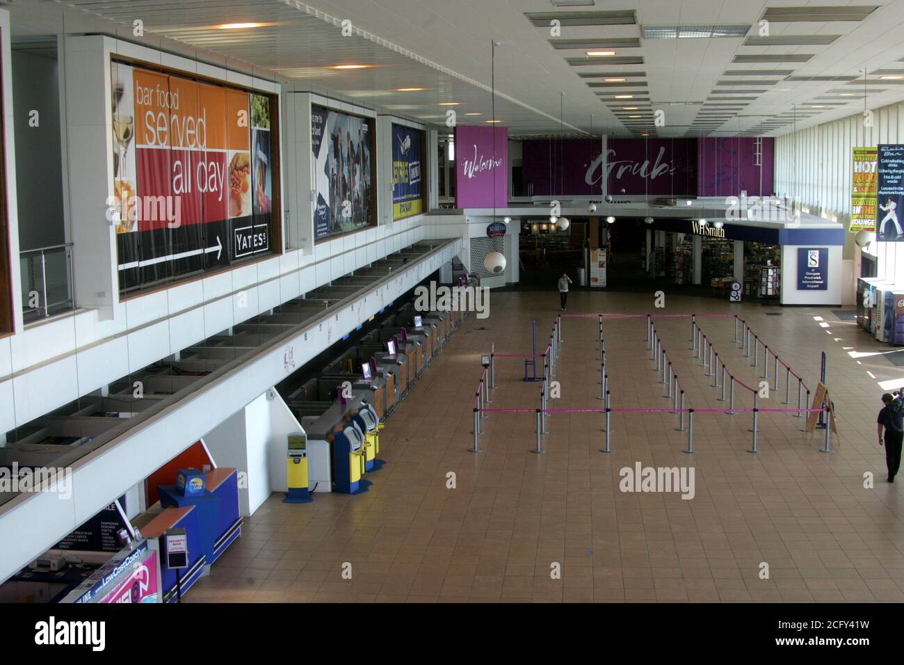 Glasgow Prestwick Airport, Ayrshire, Scotland. 16 April 2010, Terminal Building empty as a result of Icelandic Volcanic Ash closing UK airspace. Concorse empty with solitary figure on phone Stock Photo
