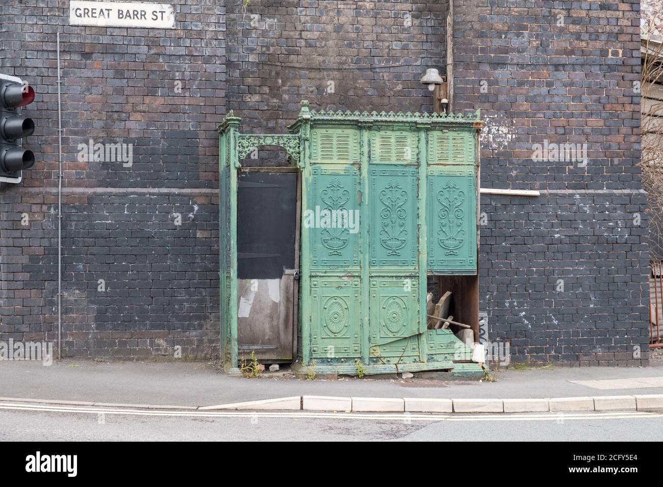 Damaged derelict Victorian cast iron mens outdoor urinal in Digbeth, Birmingham, UK Stock Photo