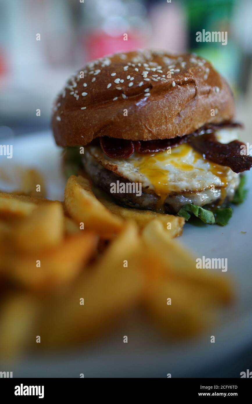 Burger with barbecue sauce eggs and fries Stock Photo Alamy