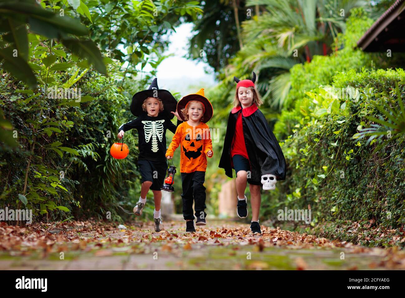 Child in Halloween costume. Kids trick or treat on suburban street ...